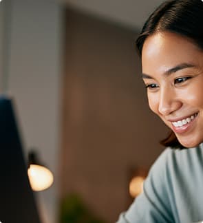 person smiling warmly at their laptop